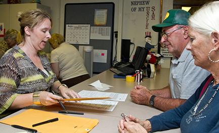(Photo by Andrew Mather, digitalBURG) Johnson County Clerk Diane Thompson helps explain voting procedures to Ed and Sandy Shields on Thursday morning.