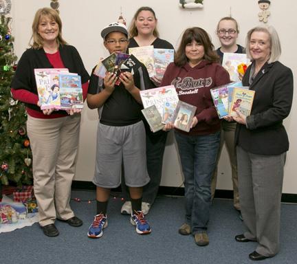 (Courtesy photo) Mary Clevenger, left, outreach coordinator for KMOS-TV, and Rosemary Olas, right, UCM’s interim director of broadcasting services, presented more nearly 900 children’s books to Johnson County Community Christmas Angel Tree volunteers, from left, Xavier Hardin, Jennifer Hardin, Valentina Kelleher and Cassie Williams.