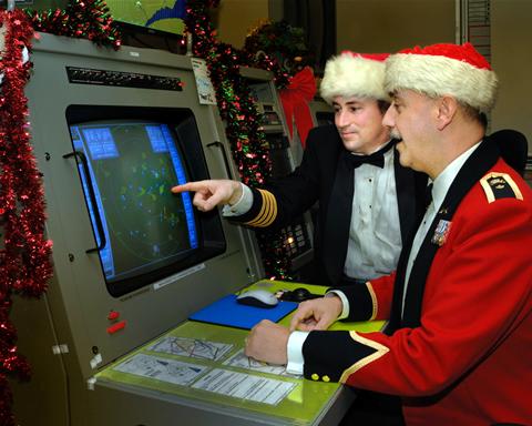 Two members of Canadian Forces check the radar screen in preparation for tracking Santa Claus.
