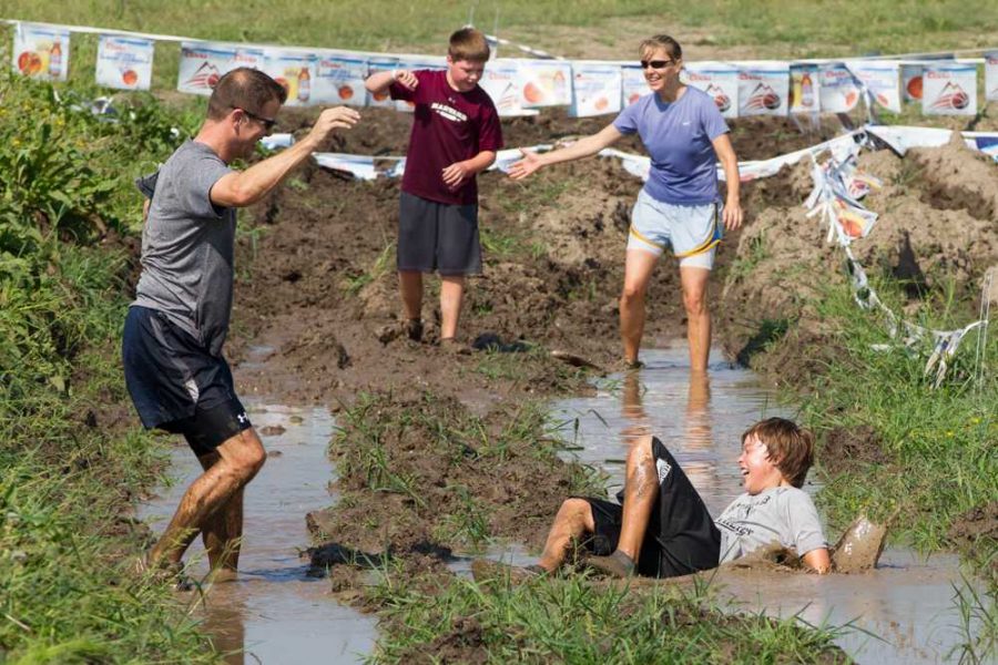 The+final+stretch+of+the+obstacle+course+took+participants%2C+like+this+family%2C+through+a+huge+pit+of+mud.