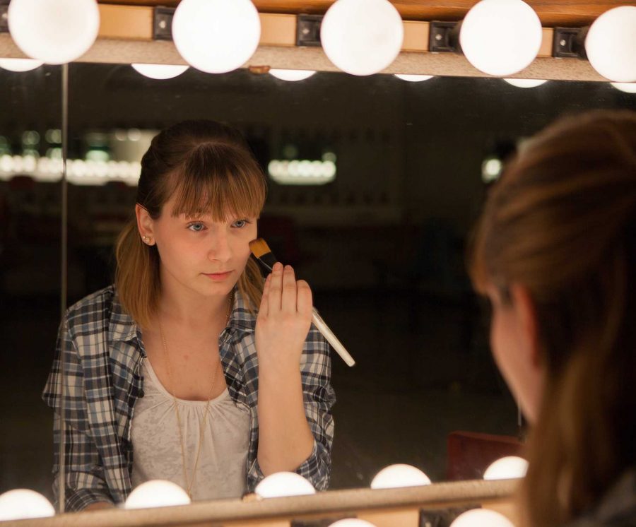PHOTO BY BRANDON BOWMAN / PHOTO EDITOR
Leah Eggimann demonstrates how an actress/actor would apply stage makeup Tuesday afternoon in the dressing room behind the Highlander Theatre.