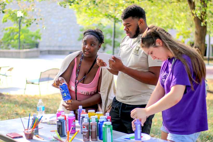 Alize Moore, a sophomore elementary education major, Justin Pough, a freshman nursing major, and Emily Lemken, a freshman physical therapy major, stand at the paint table to get paint for their art pieces.
(Photos by Peter Spexarth, for the Muleskinner)
