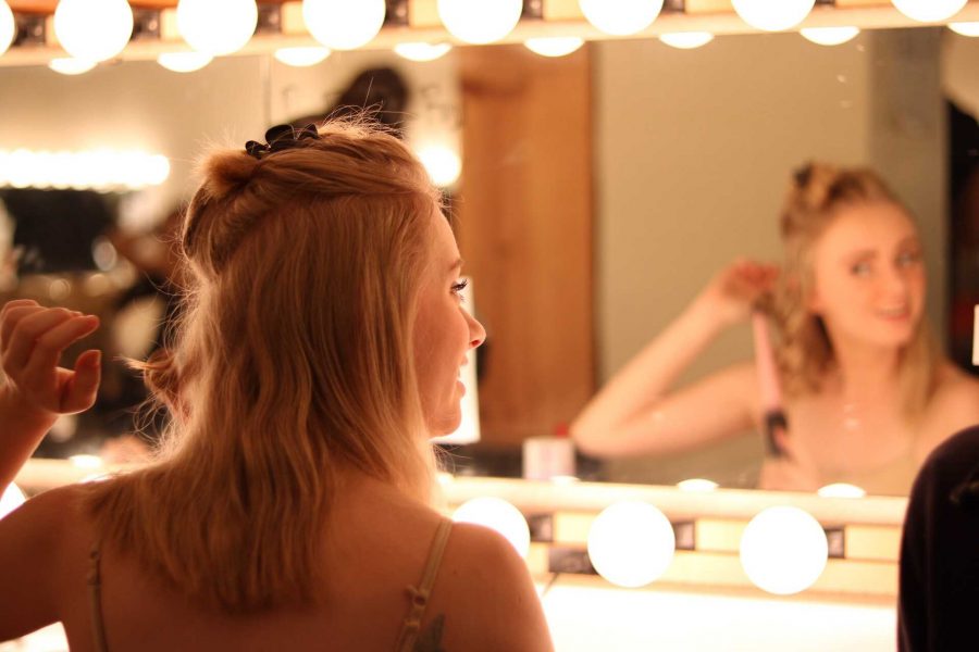Iliana Miller, a freshman speech education major, curls her hair before performing in the musical Gypsy. (Photo by Molly Burnam) 