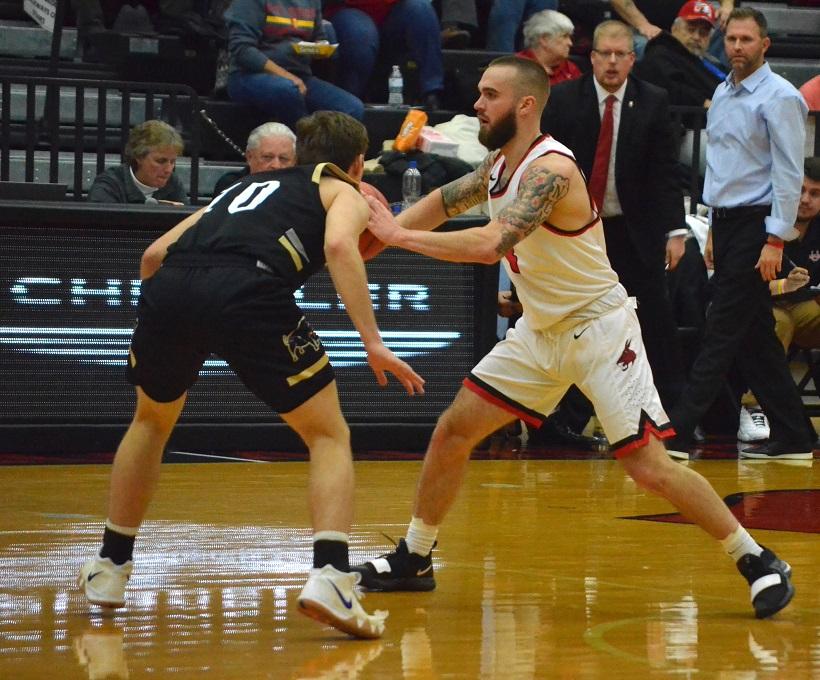 Junior guard Blake Spellman makes a pass in the Mules 82-57 win over Harding Friday at the Multipurpose Building. Spellman scored in double figures in both of the Mules wins over the weekend. (Photo by Erica Oliver/Assistant Photo Editor)