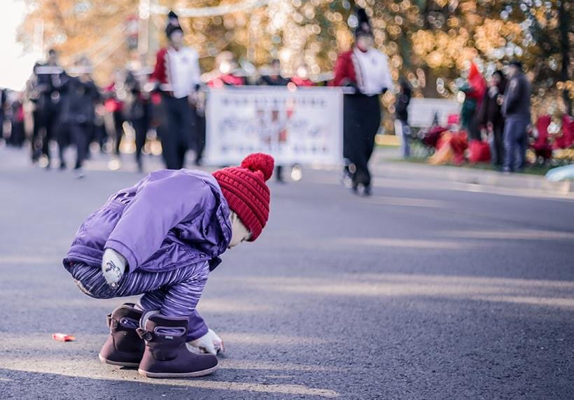 A parade spectator takes advantage of a break in the action to go after some candy at the 2019 Homecoming parade. (Photo by Alexis Dyser)