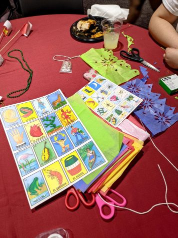 This image is a photo of various games and crafts. There's assorted paper of various color, strings and scissors on top of a red surface.