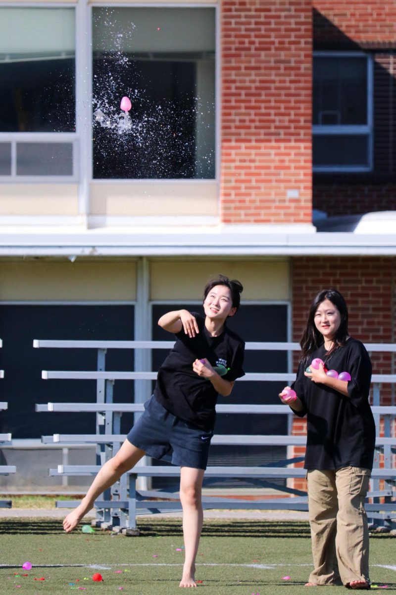 Soeun Lee, junior, throws water balloons while Suyeon Kim, senior, looks on. The water balloon fight was held on the East Field and was organized by MO’s Activities Council. Photo by Mingzhu Zhu