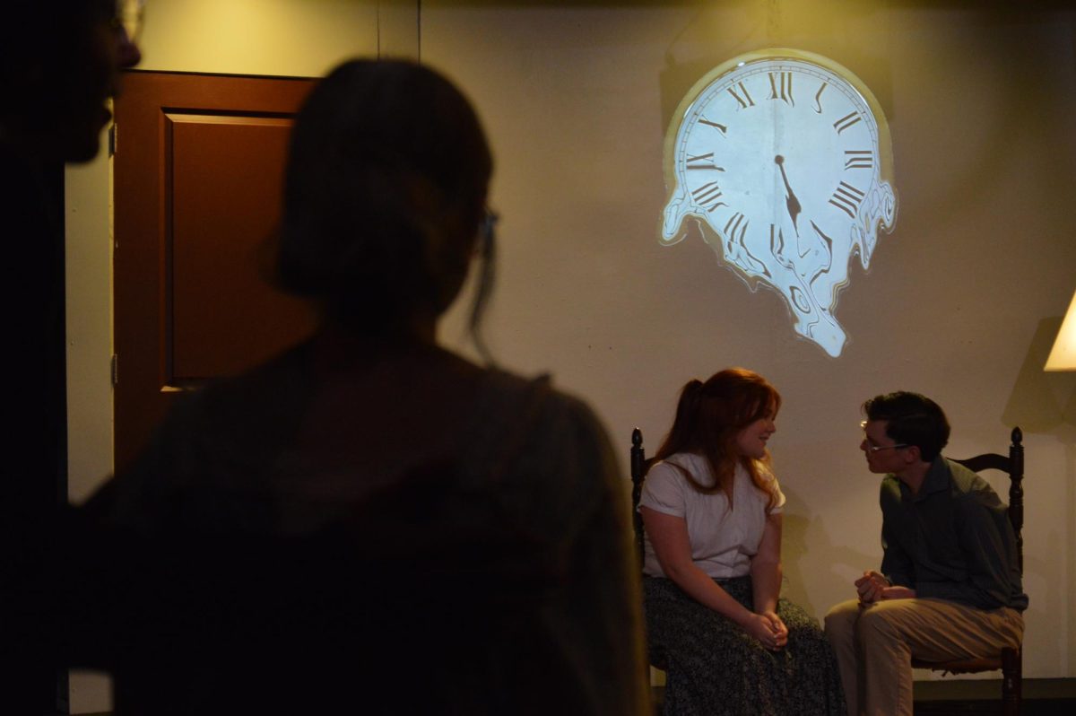 From left, student actors Allie Whitney and Dawson Black sit at the back of the room engaged in conversation while a silhouetted Lizzy Molina watches. The play, “A Long Trip,” was one of the UCM Studio One-Acts performed on Sept. 14 and 15 at the Nickerson Black Box Theatre.