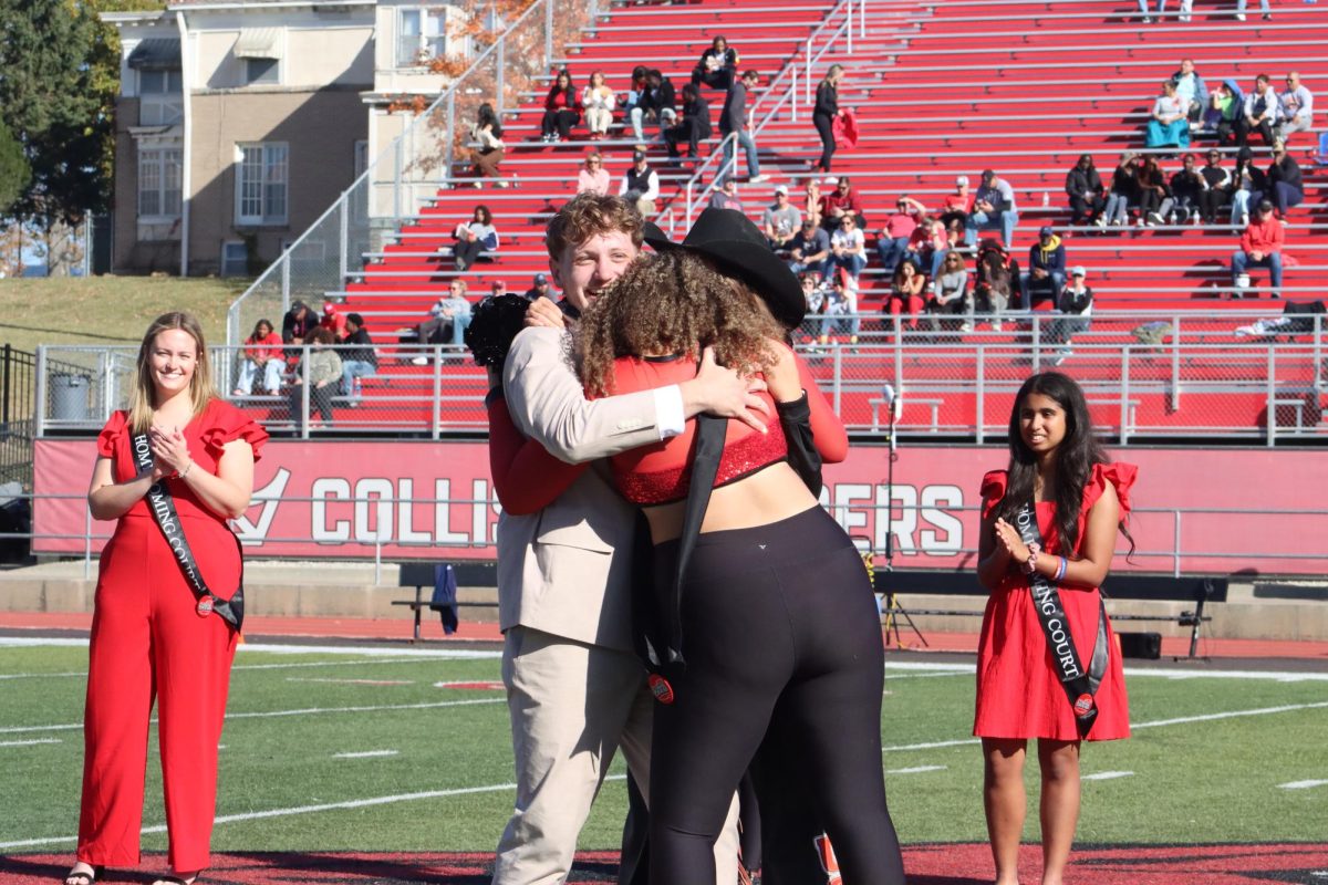 The 2024 UCM Royalty Winners Senior Derek Walsh, Junior Alexis Barnes and Junior Emma Lock embrace after being crowned homecoming royalty. The three royalty winners were announced during halftime of the homecoming football game against Washburn University on Oct. 26.