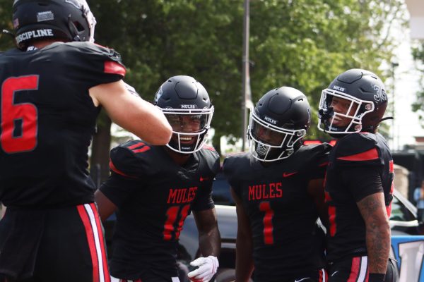 From left Senior Jake Lippe, Senior NyNy Davis, Senior Zach Patterson and Freshman LaAngelo Bell celebrate a successful touchdown. The Mules won 36-35 with Senior Zach Patterson leading the game in receiving yards and Bell leading the game in rushing yards on Sept. 28 at the Audrey J. Walton Stadium.