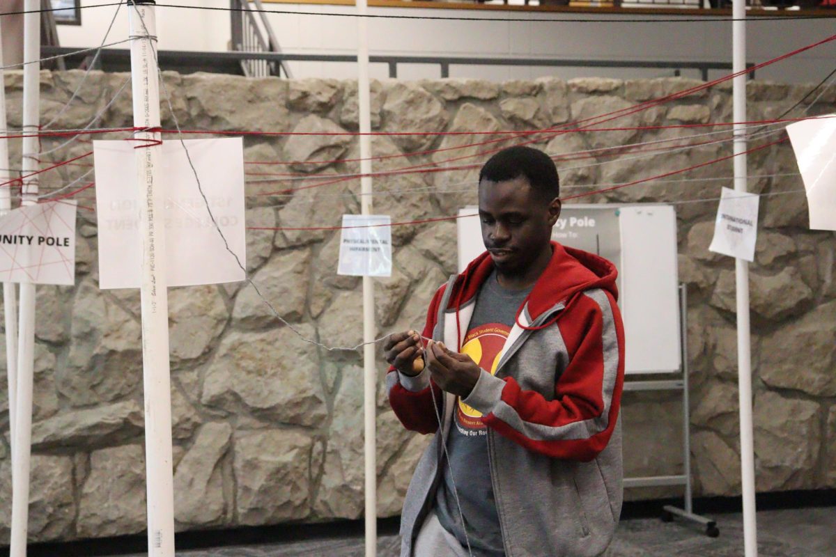 Masters student Abu Bakarr Kanu works on wrapping string around a Unity Pole for the Unity Pole event on Feb. 11. Unity Week ran during Feb. 9 to 12 at the Elliot Student Union.