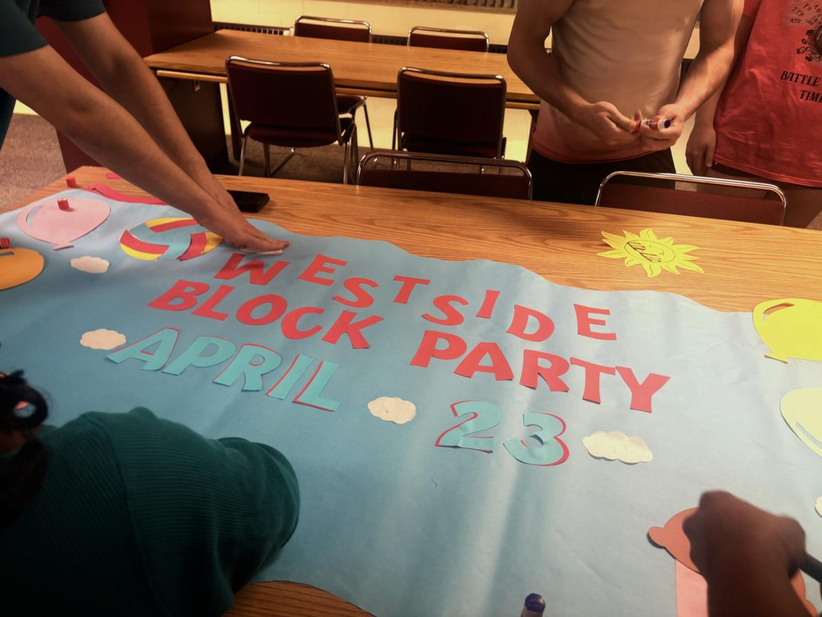 Houts-Hosey CAs, Osa Ogbevoen, Ollie Willis-Howard, Anthony Baumann, Gavin Moore and Alex Moore, are working on a banner for the West Side Block Party.