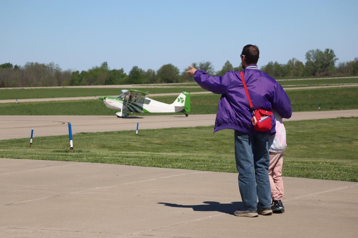 Attendees watch while aircraft in the traffic pattern at Skyhaven Airport land and take off. The Flight Team Fundraiser was open to the public and included a cookout, exhibits and silent auction.