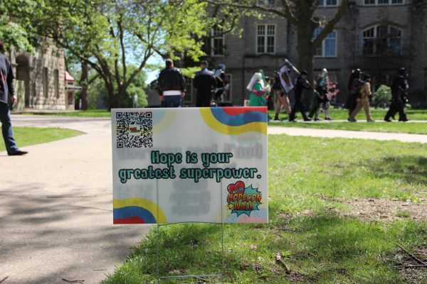 A sign stating, “Hope is your greatest superpower” is displayed while cosplayers walk in the background. The sign was placed as part of the eighth annual Cos4Hope walk held at UCM on April 18.